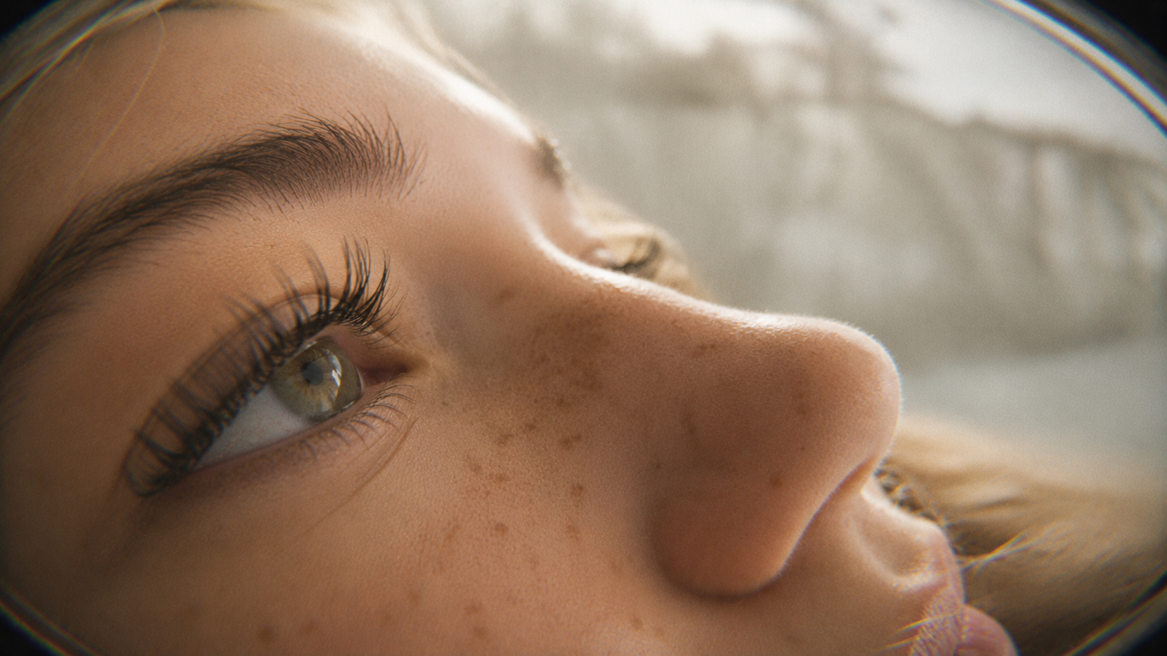 Extreme close-up of an eye with long eyelashes seen through a circular lens