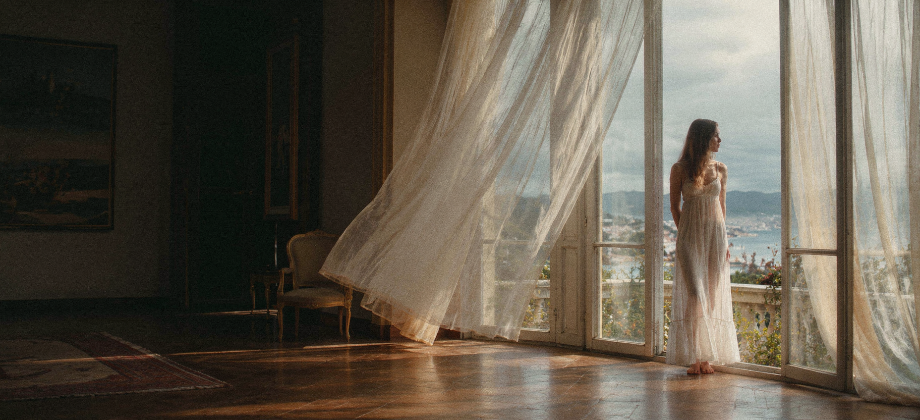 wide-angle view of curtains blowing in the wind, seen from inside a dimly lit room